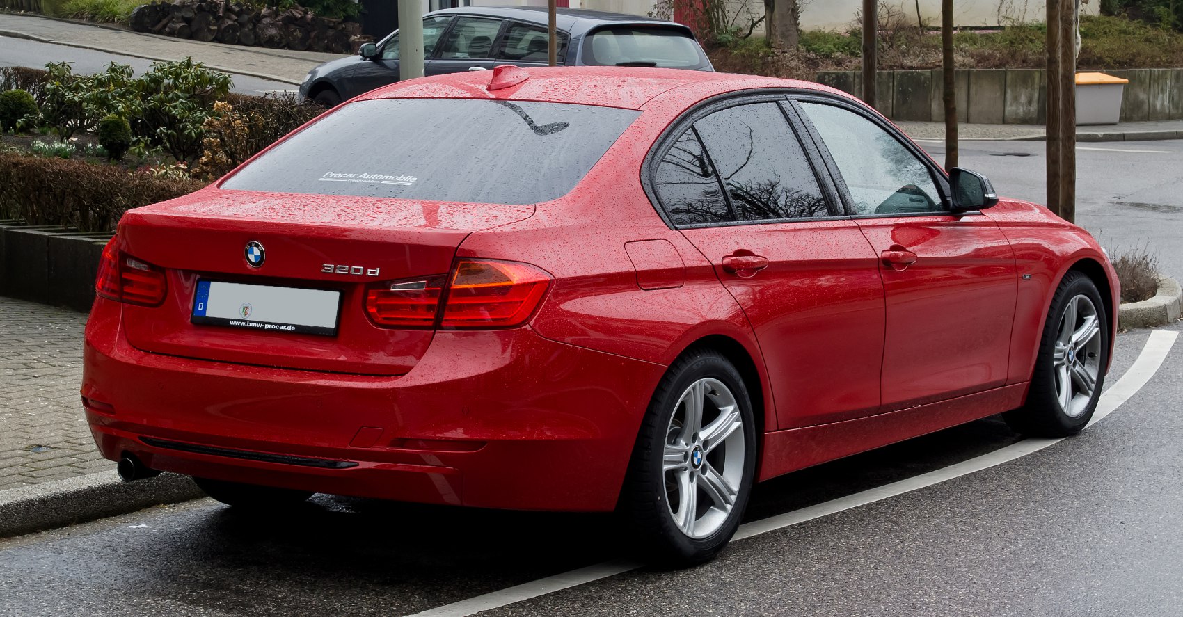 Red sedan with LED taillights, shark fin antenna, and alloy wheels.