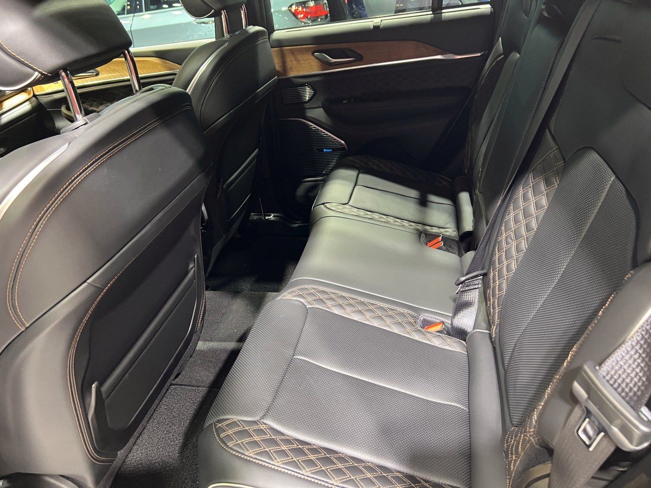Quilted leather rear seats with contrast stitching and wood trim panel