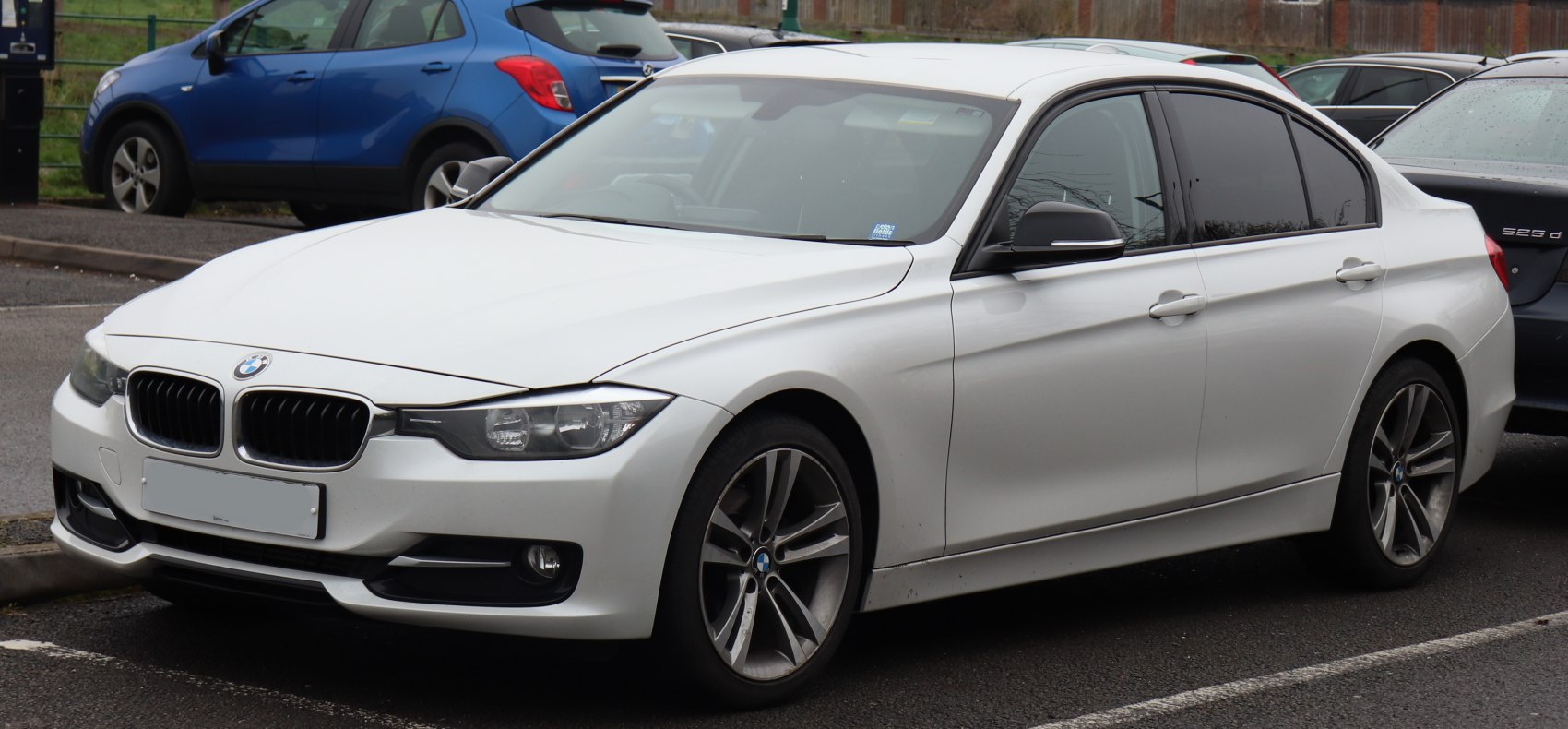 White sedan front-side view with modern headlights and alloy wheels