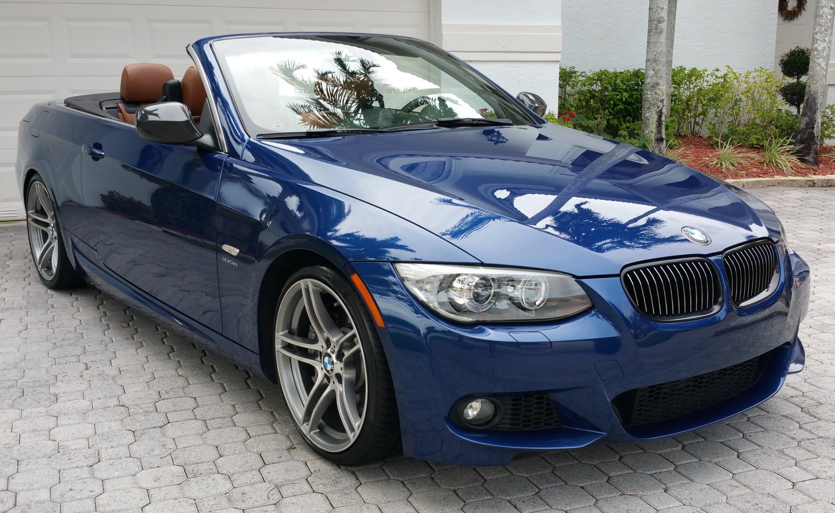 Blue convertible with kidney grille, alloy wheels, and open roof.