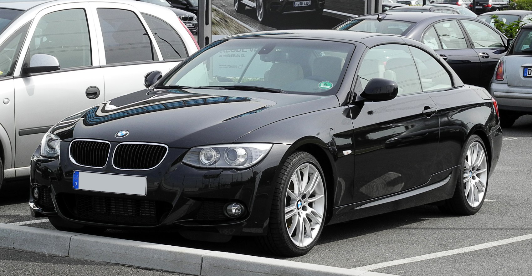 Front and side view of a sleek black convertible with distinctive grille and alloy wheels.