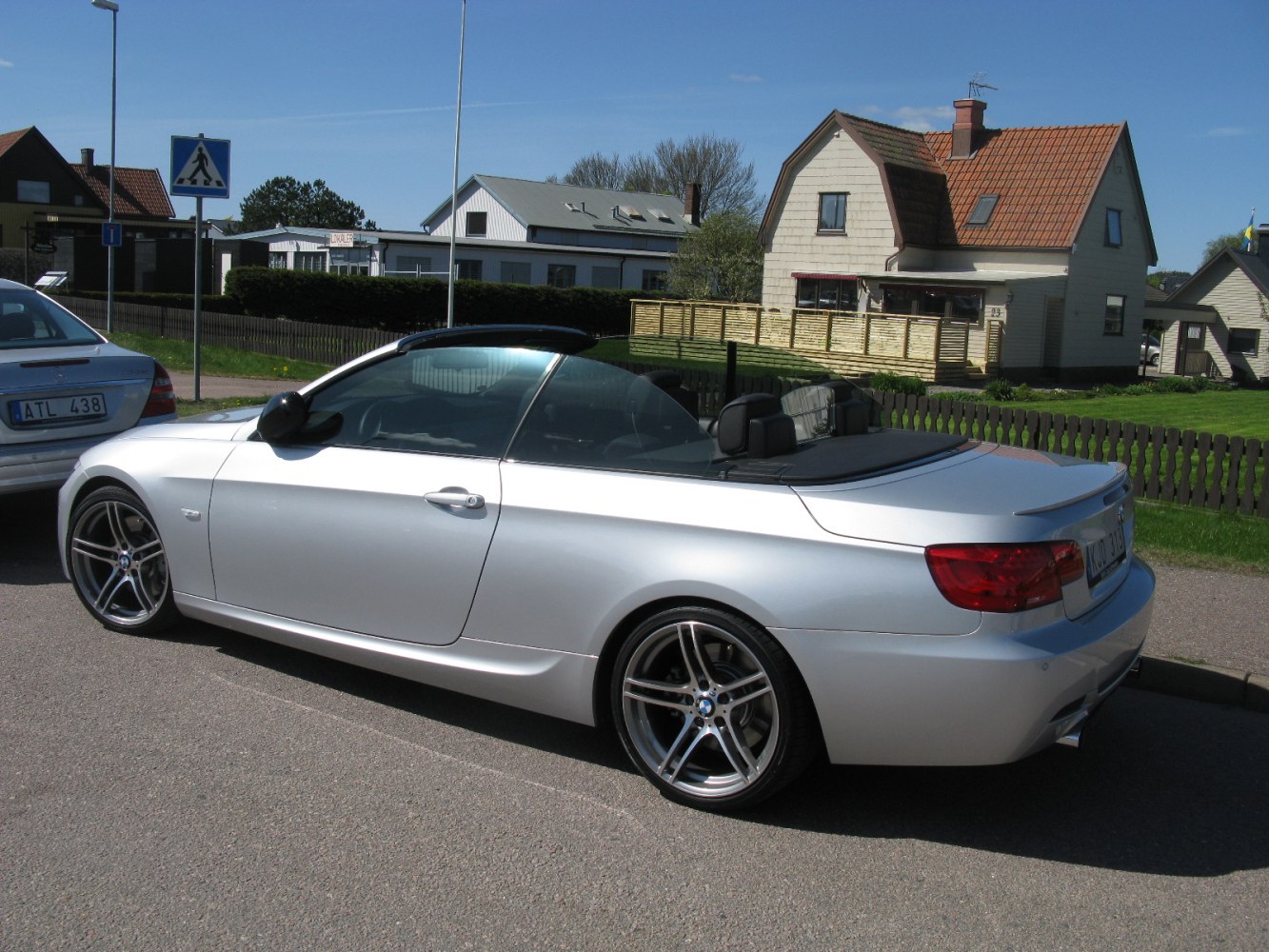 Silver convertible with soft top down, sporty rear design, alloy wheels