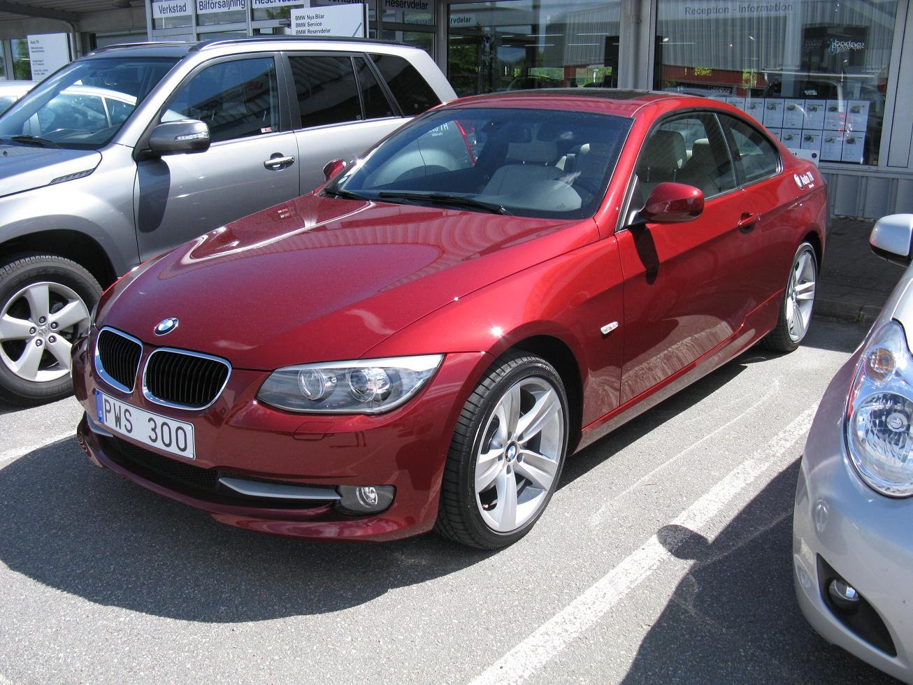 Red coupe front and side view with headlights and alloy wheels