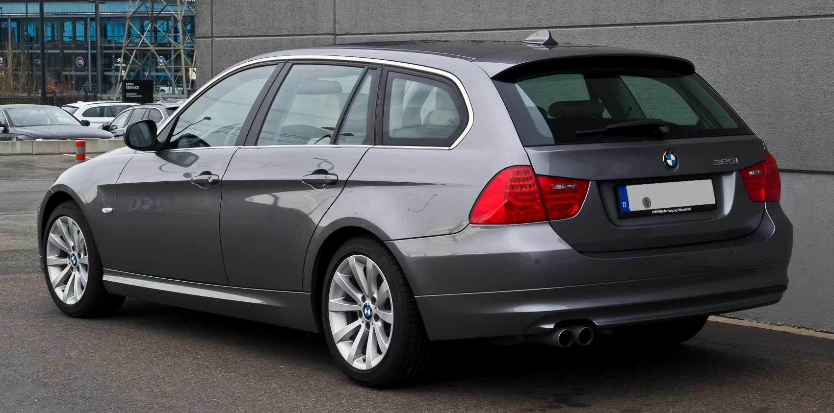 Rear side view of grey estate car with twin exhaust and alloy wheels