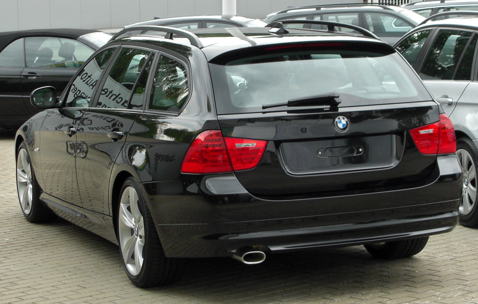 Rear view of black wagon with roof rails and single exhaust