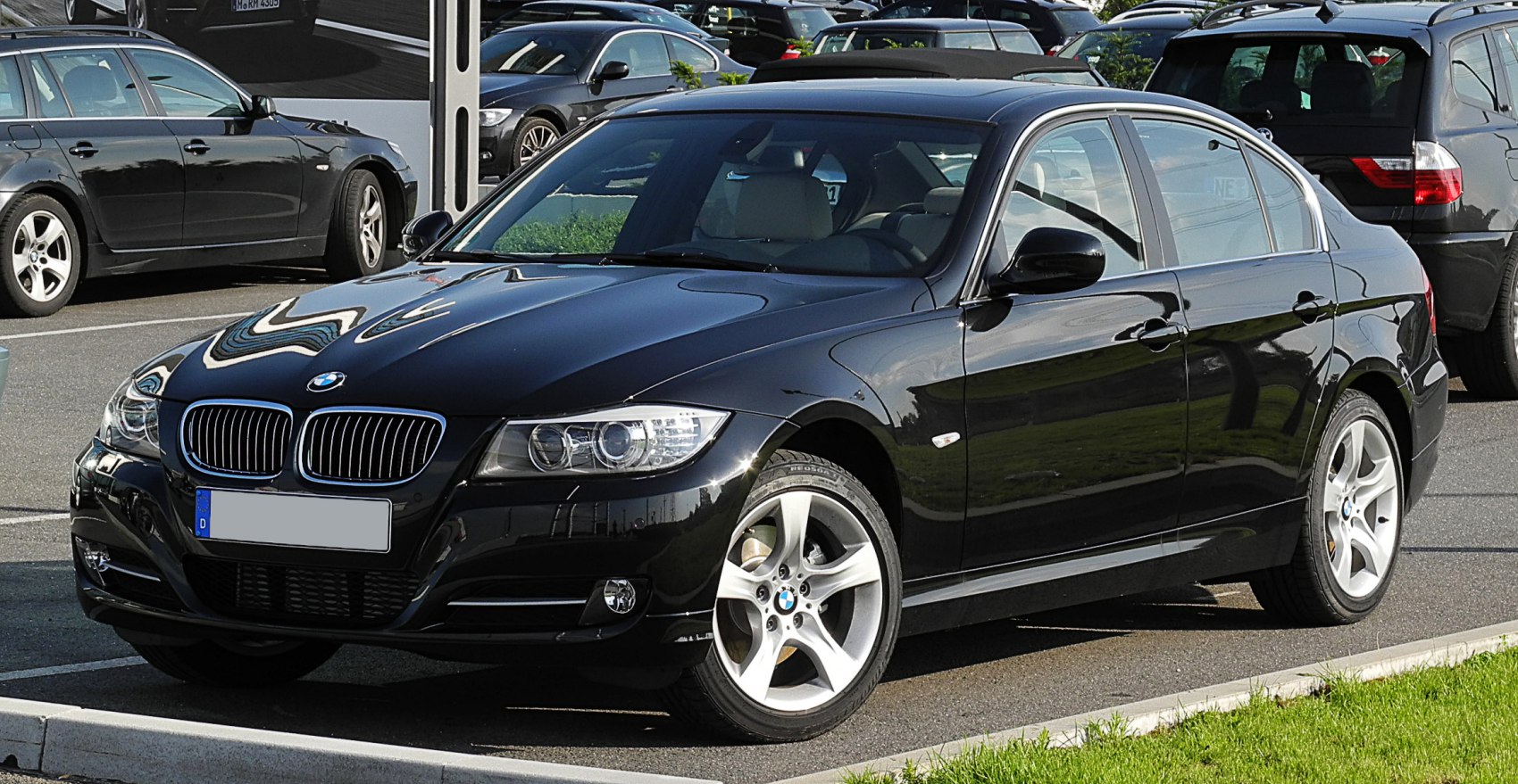 Front kidney grille and alloy wheels of a black sedan
