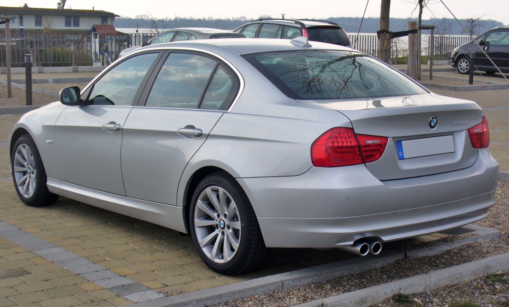 Rear and side view of silver sedan with twin exhausts and alloy wheels