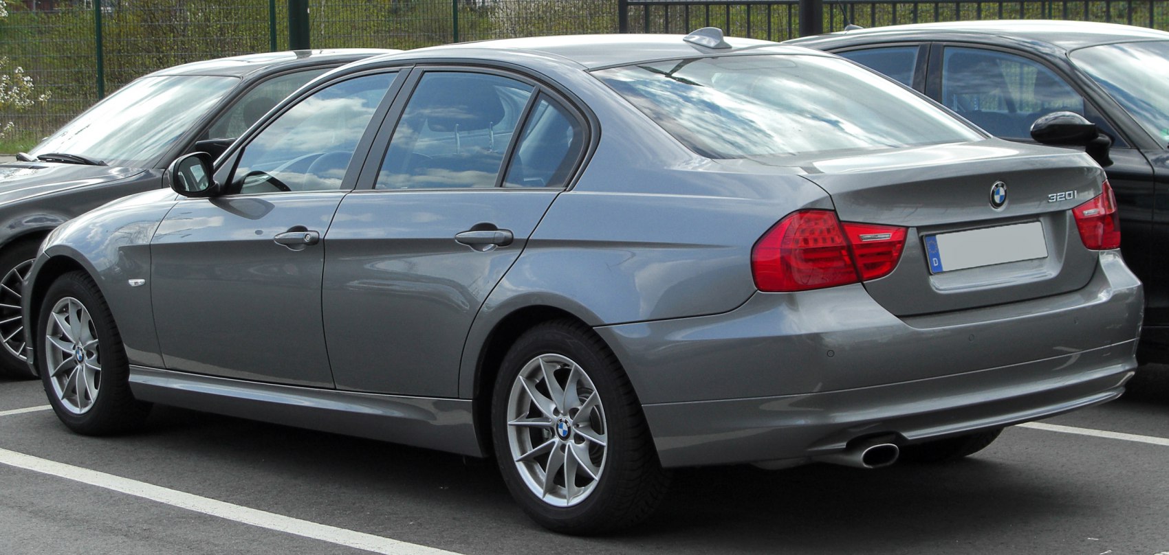 Rear side view with tail lights and alloy wheels of a sedan