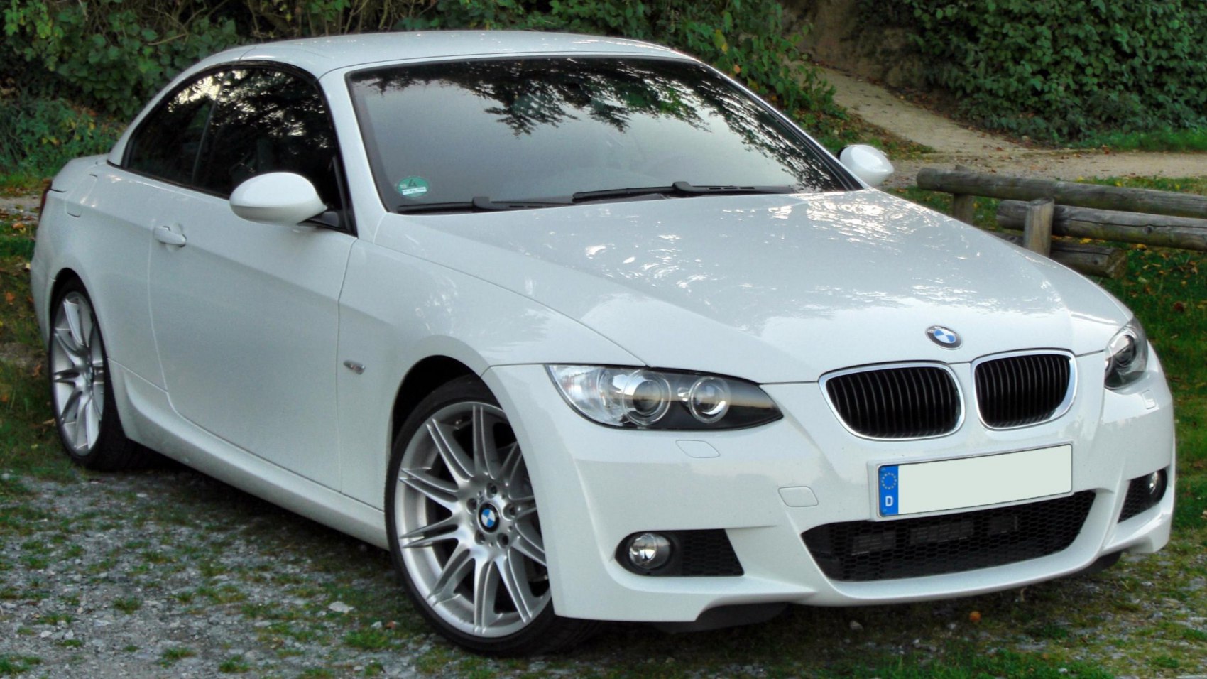 White convertible front view with distinctive headlights and alloy wheels
