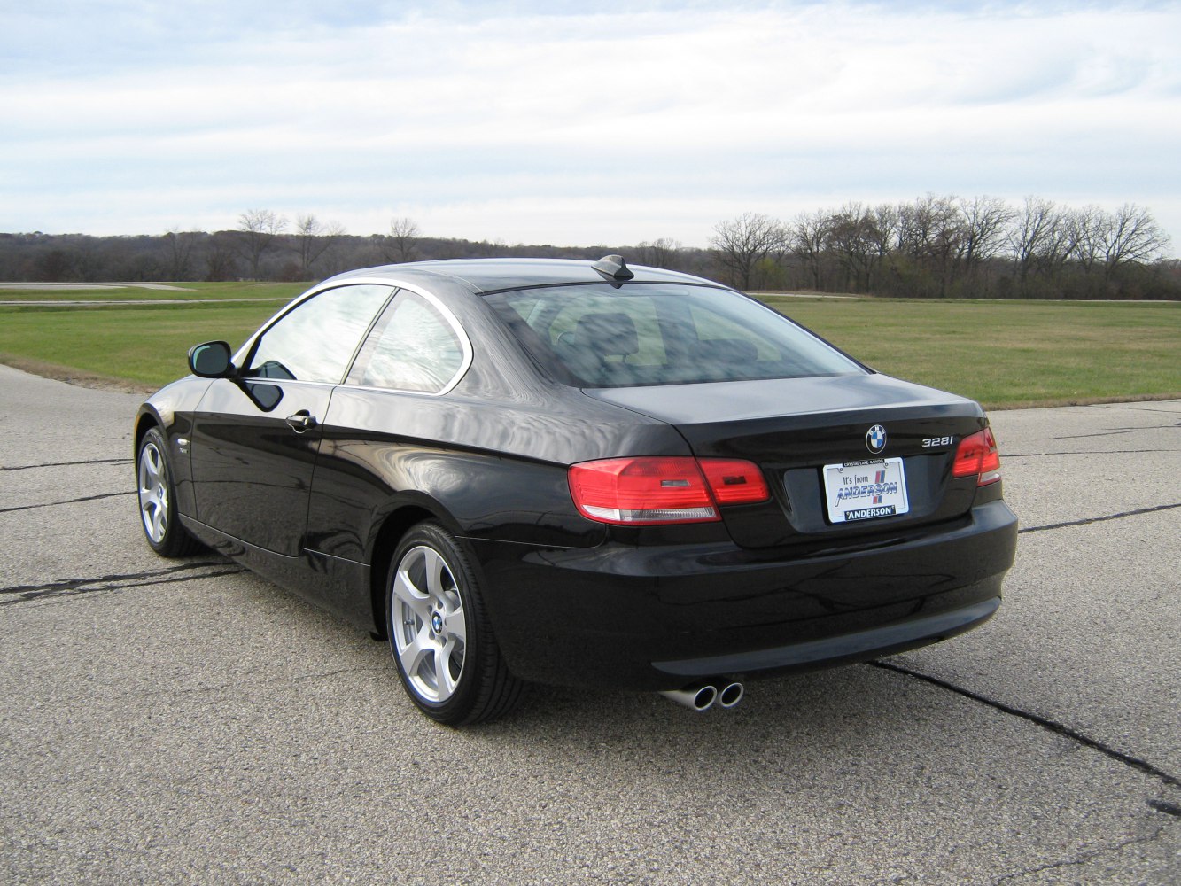 Rear view of a black coupe with distinct tail lights and dual exhaust