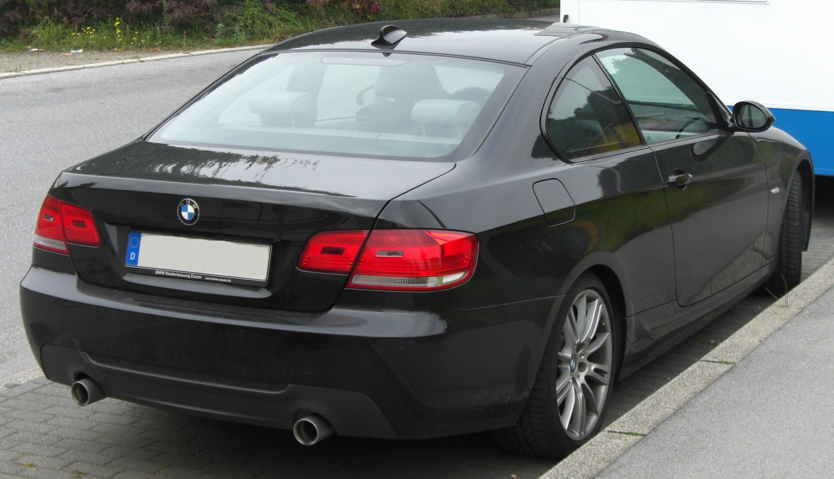 Rear view of coupe with distinctive taillights and dual exhaust pipes
