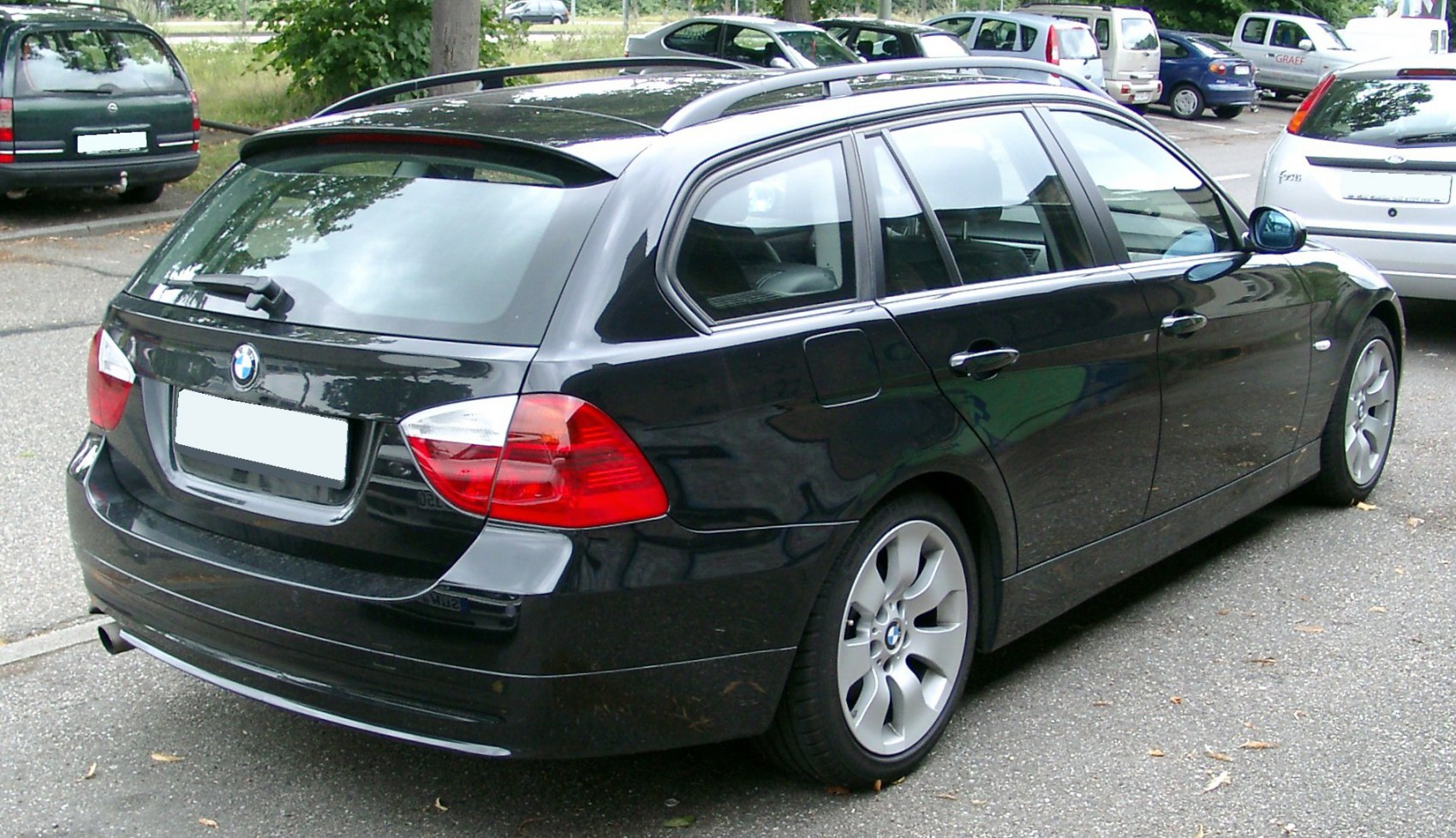 Black estate car rear view with alloy wheels and roof rails