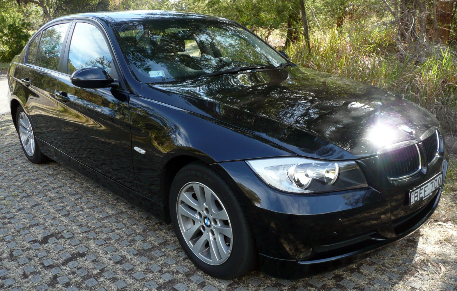Front side view of black 3 Series Sedan with alloy wheels and distinct headlights