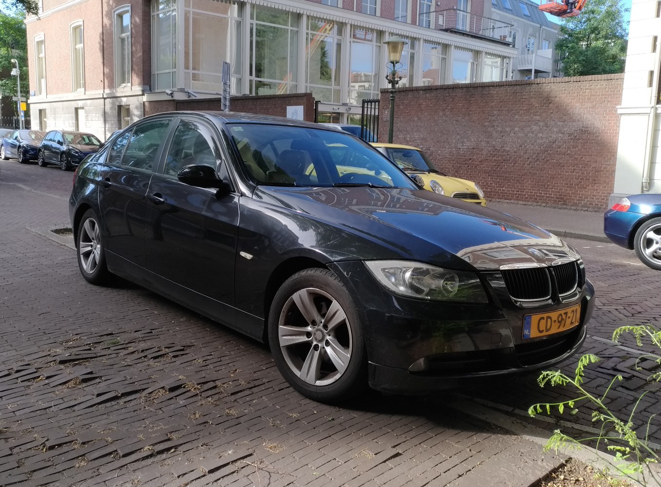 Black sedan parked on street with visible front side design