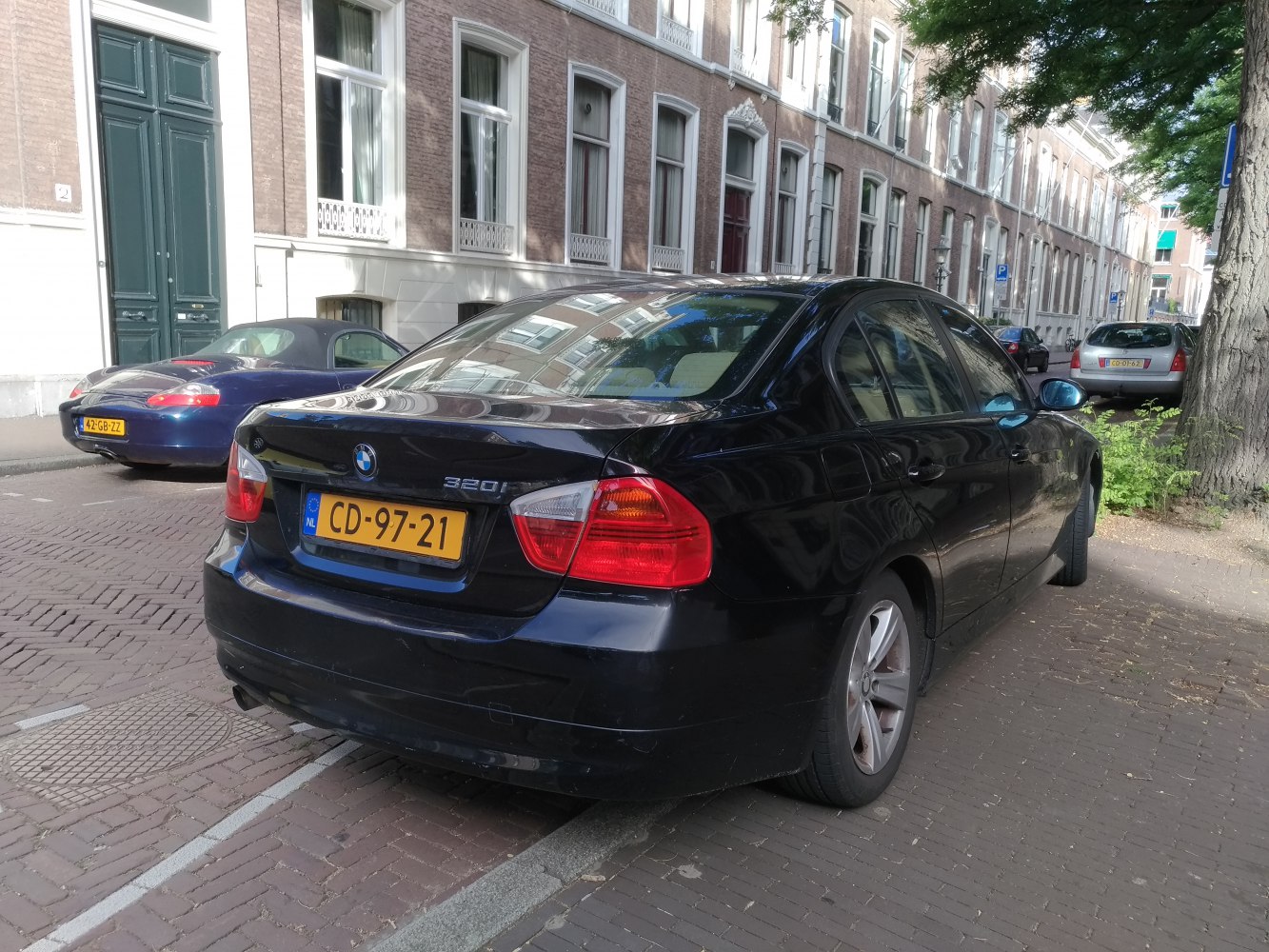 Rear view of a black 4-door sedan with distinct tail lights and 320i badge.
