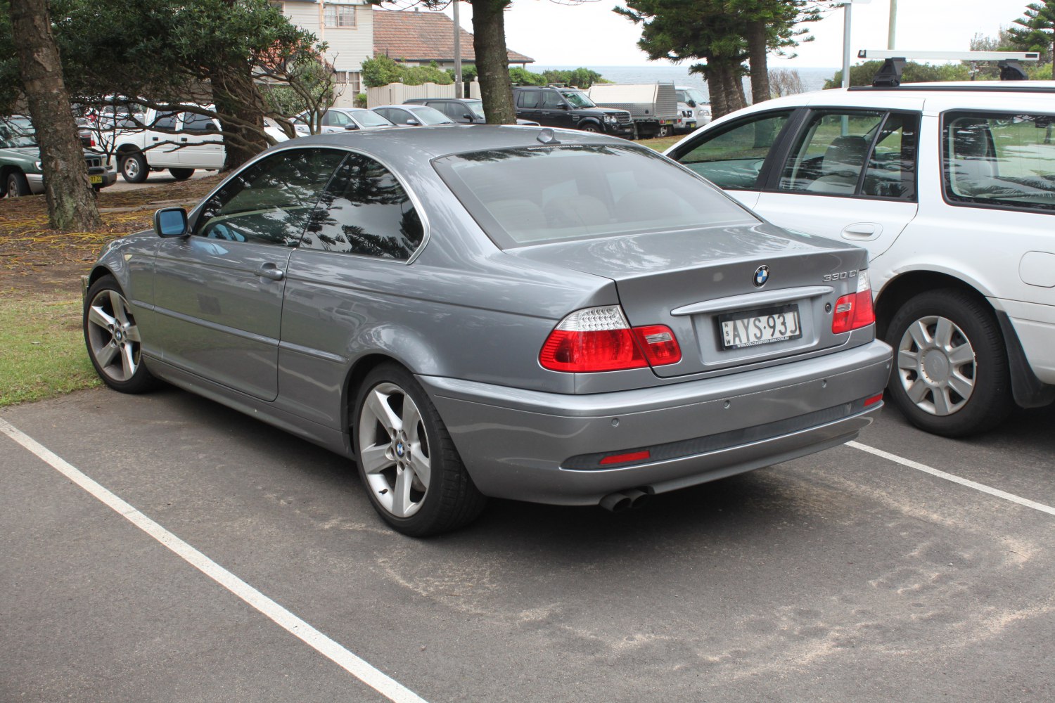 Rear view of coupe with tail lights and alloy wheels