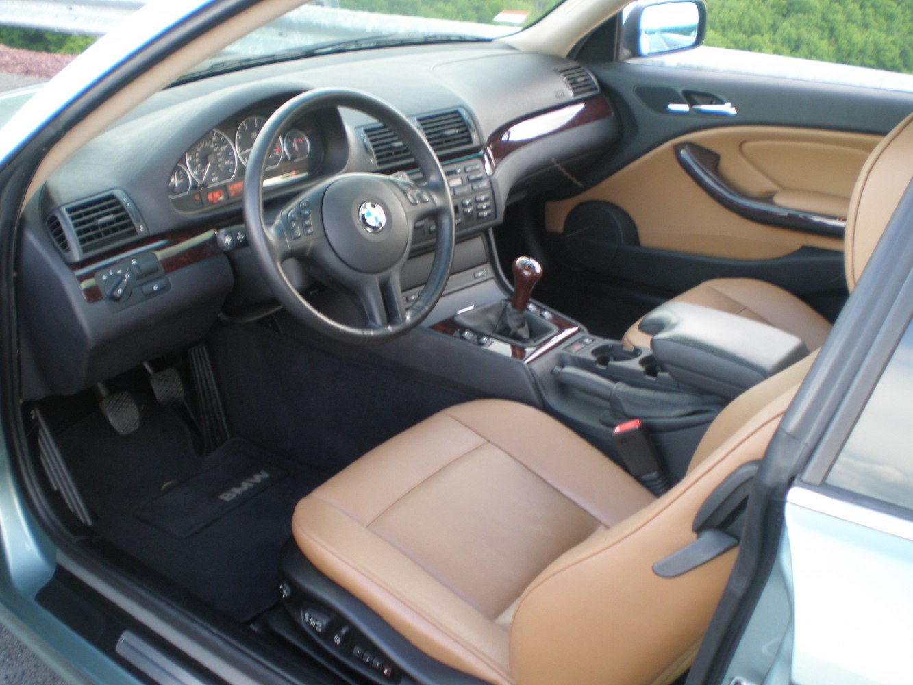 Tan leather interior, manual gear shifter, steering wheel, dashboard