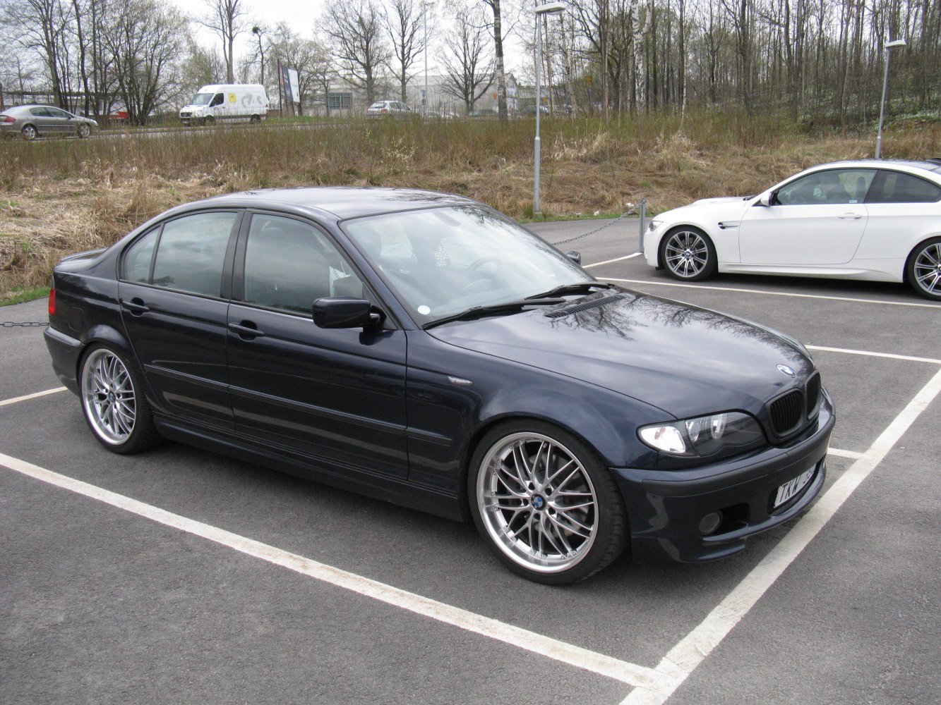 Dark blue sedan with multi-spoke alloy wheels parked in lot