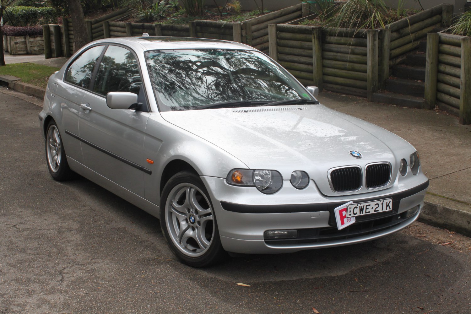 Silver four-door sedan with dual round headlights and multi-spoke alloy wheels
