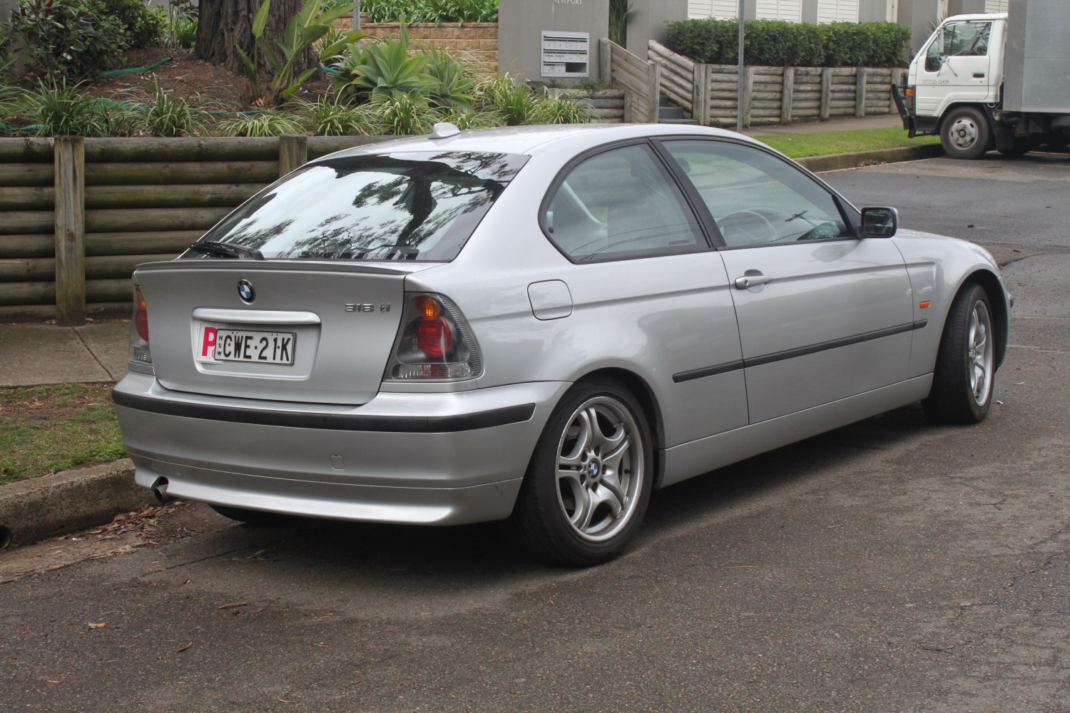 Rear side view of silver compact coupe with distinctive taillights and alloy wheels