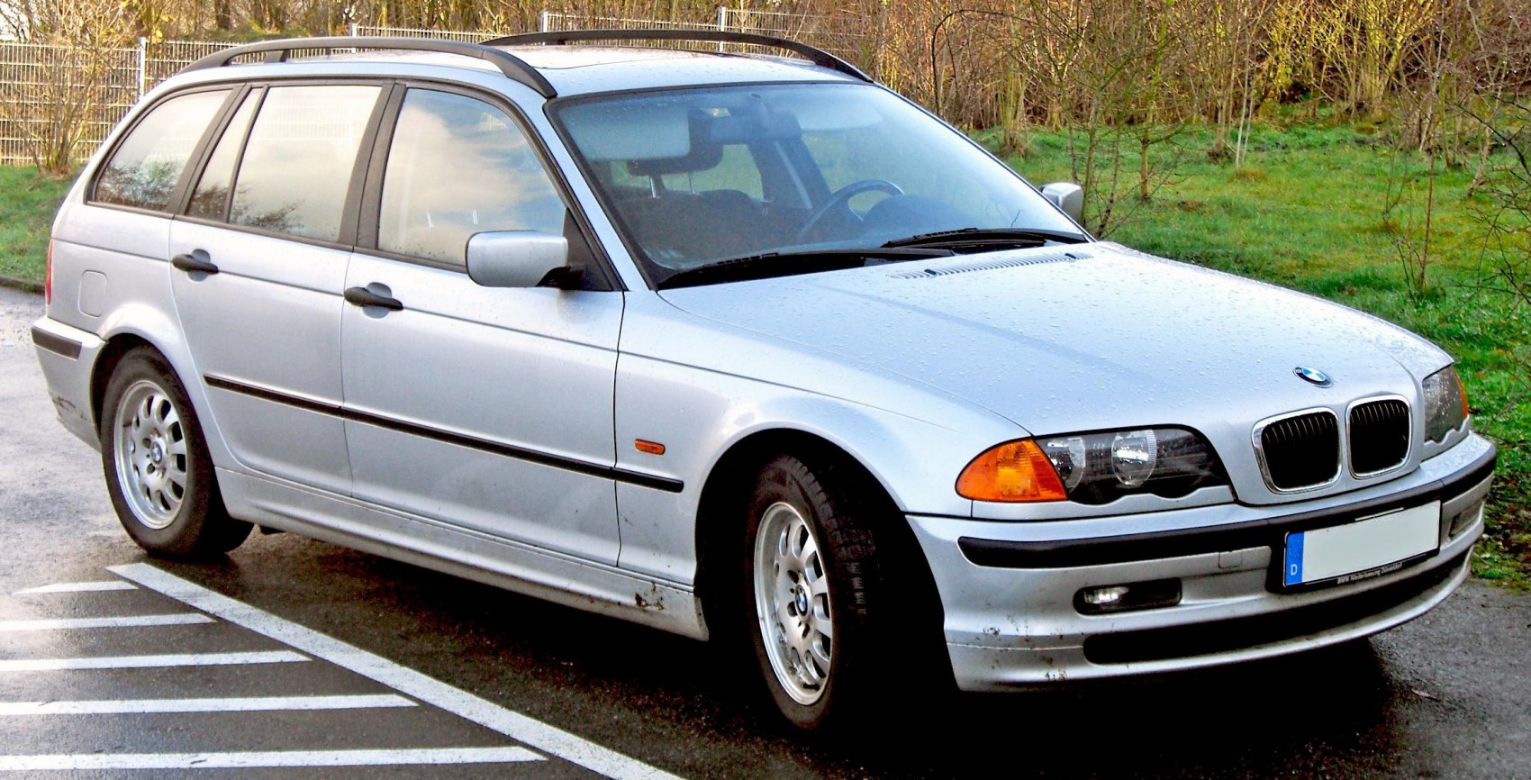 Silver BMW 3 Series Touring E46 front side view with distinctive headlights and alloy wheels