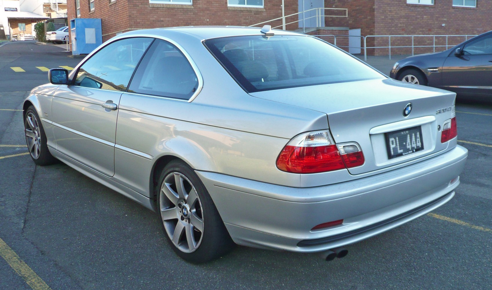 Silver coupe rear view with taillights and dual exhaust tips