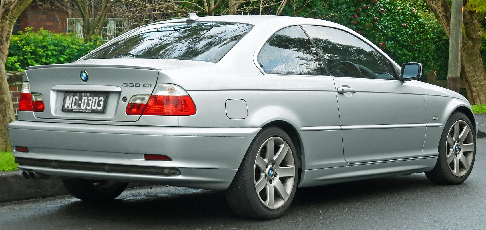 Rear view of silver coupe with distinct taillights and alloy wheels