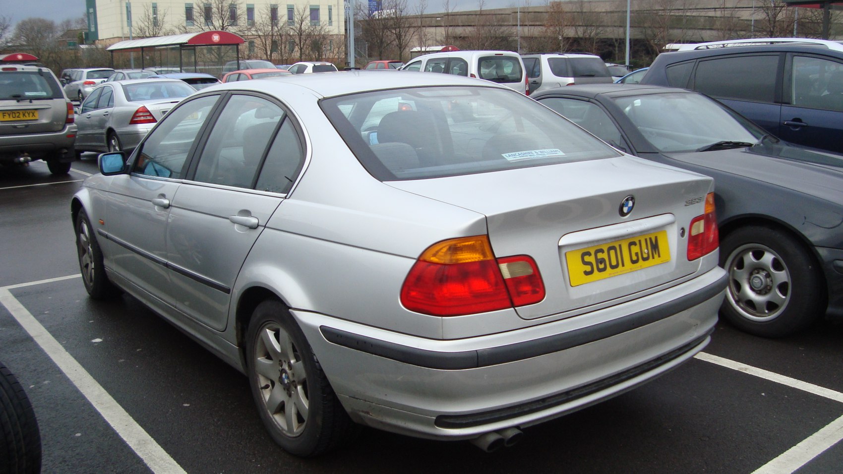 Silver sedan rear and side view with tail lights and alloy wheels