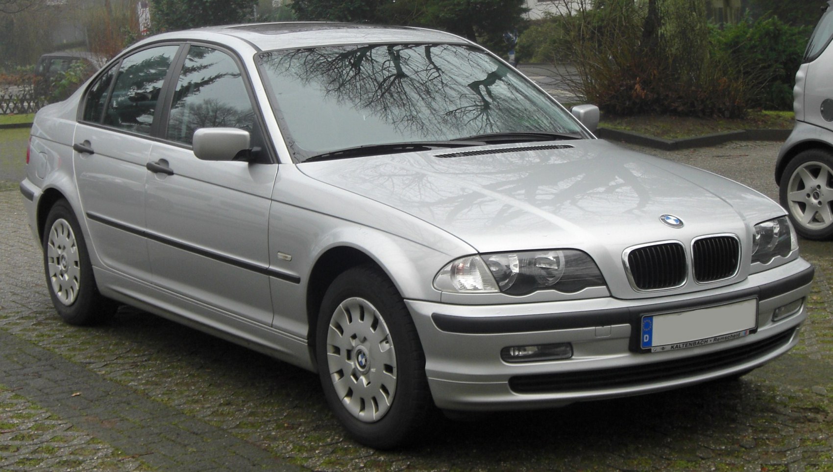 Front headlights and alloy wheels on a classic sedan.