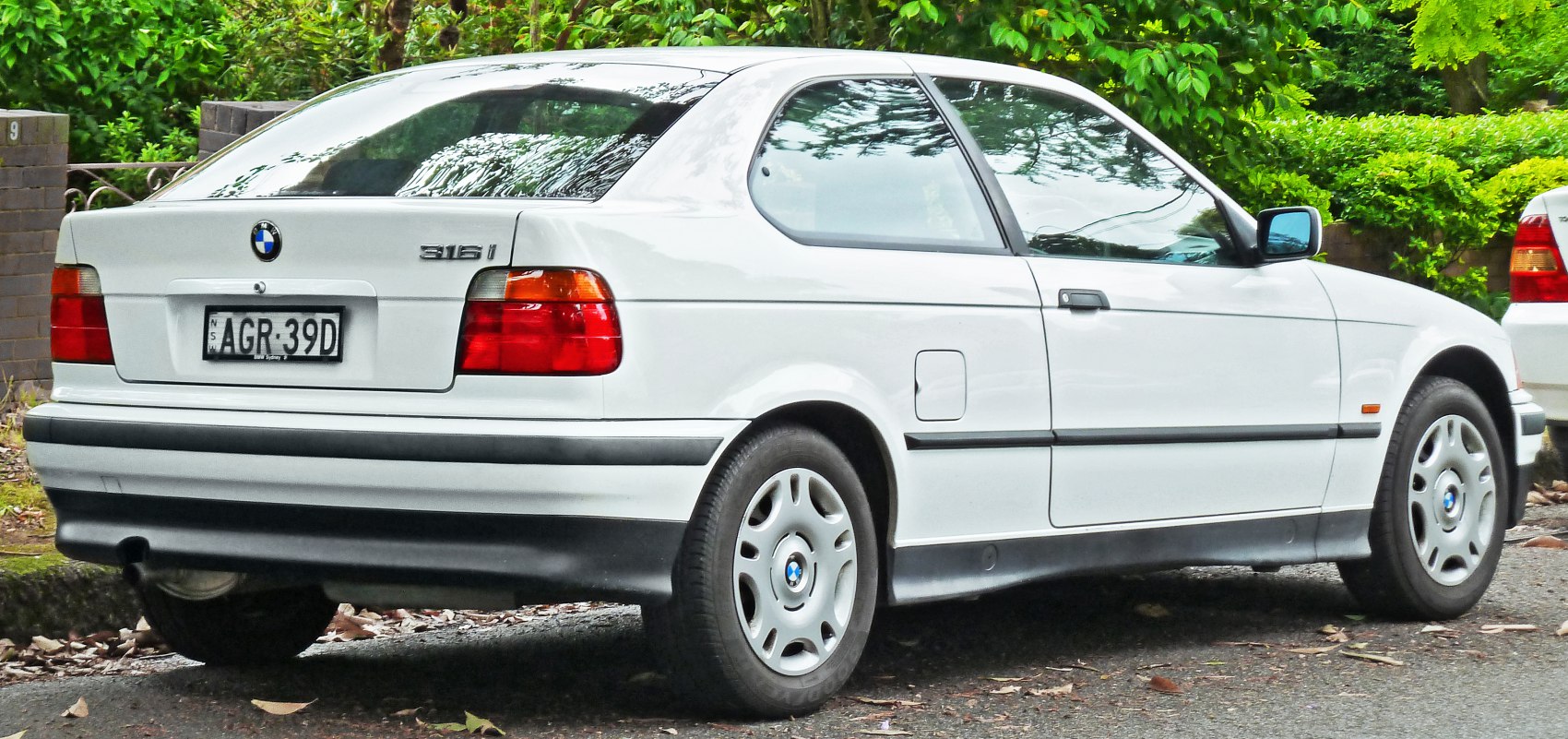 Rear side profile of a white 3-door hatchback with distinct taillights and wheel design