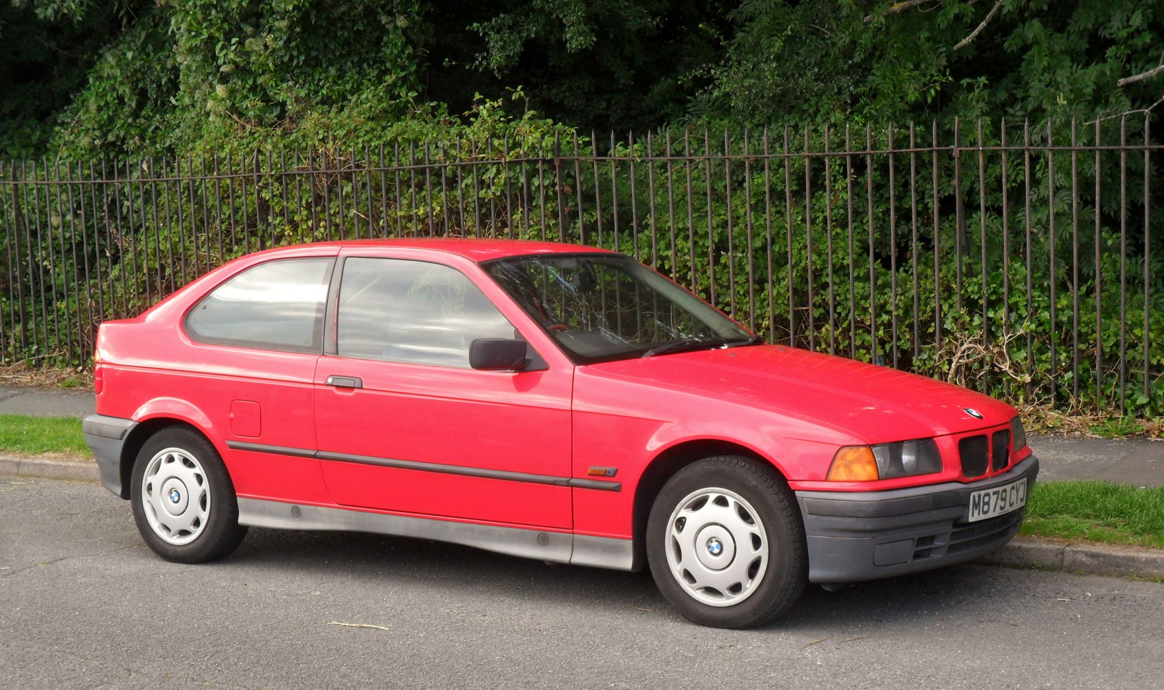 Red hatchback with alloy wheels, side profile view