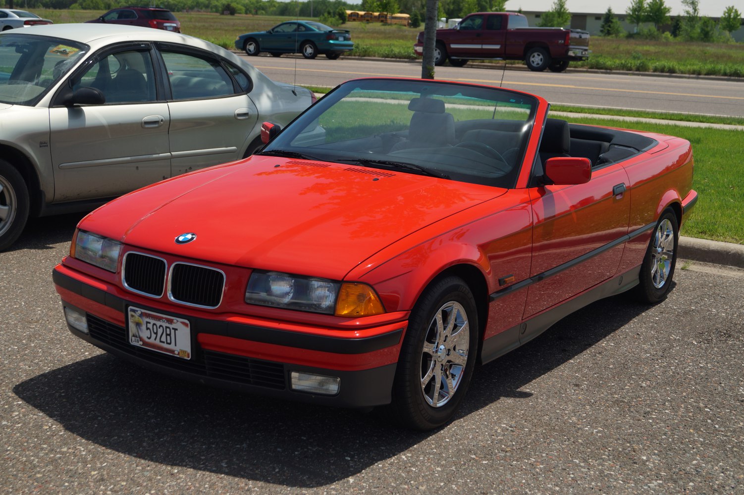 Red convertible with chrome wheels and classic front grill design