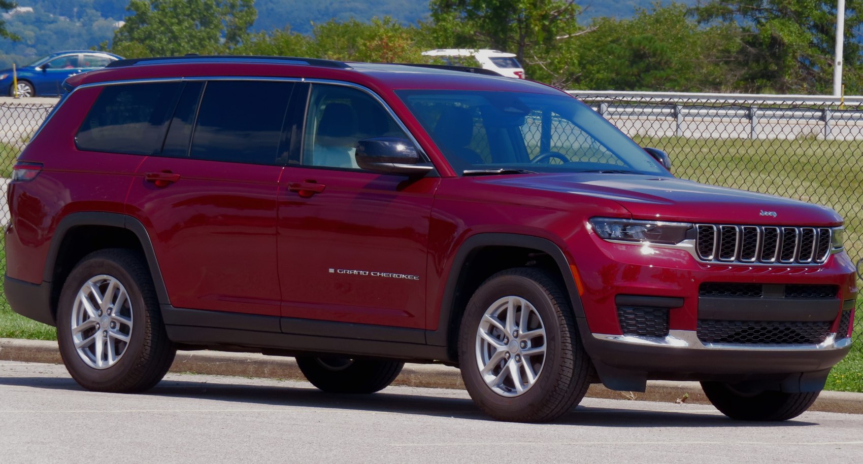 Front and side view of a red midsize SUV.