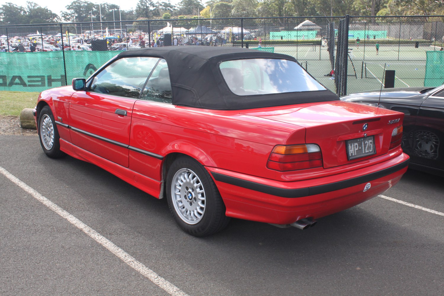 Red convertible with black soft top and alloy wheels