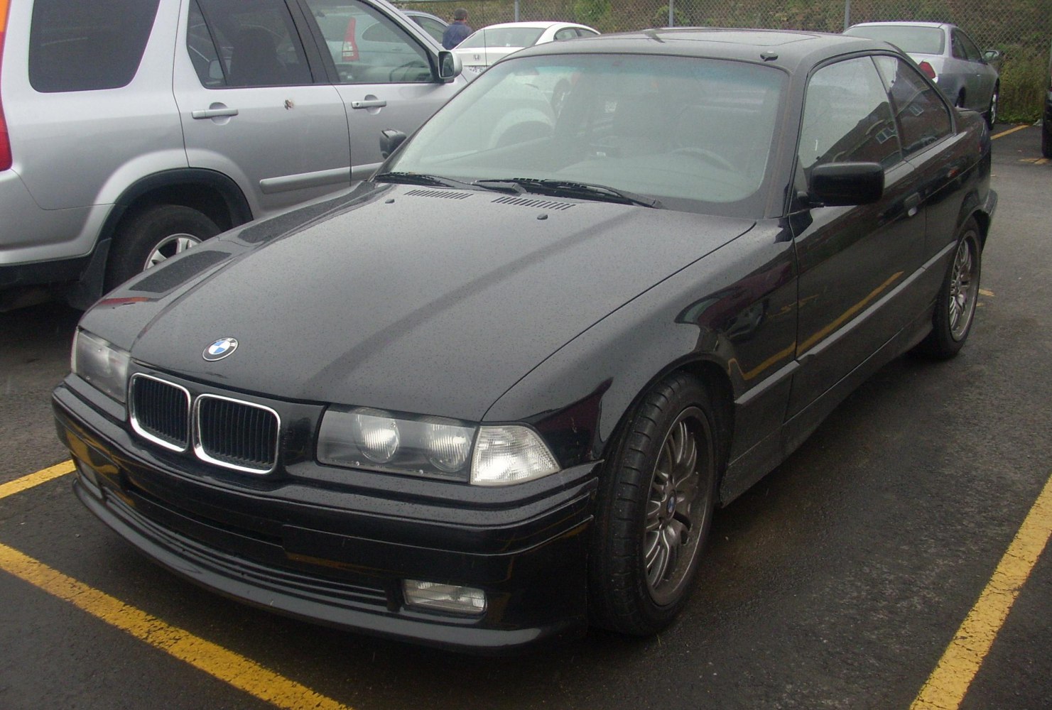 Front side view with headlights and kidney grille of a black coupe