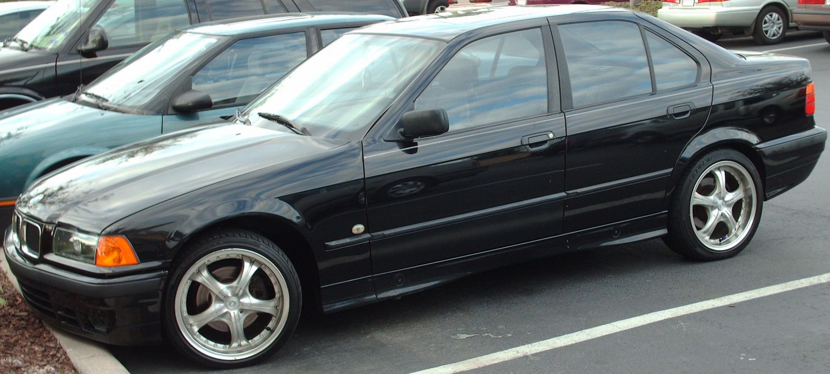 Black sedan with chrome five-spoke alloy wheels