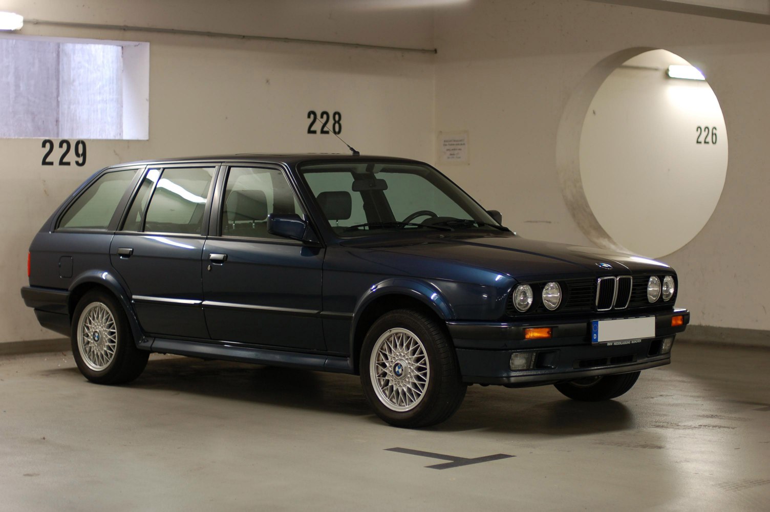 Dark blue 1980s wagon with round headlights and alloy wheels