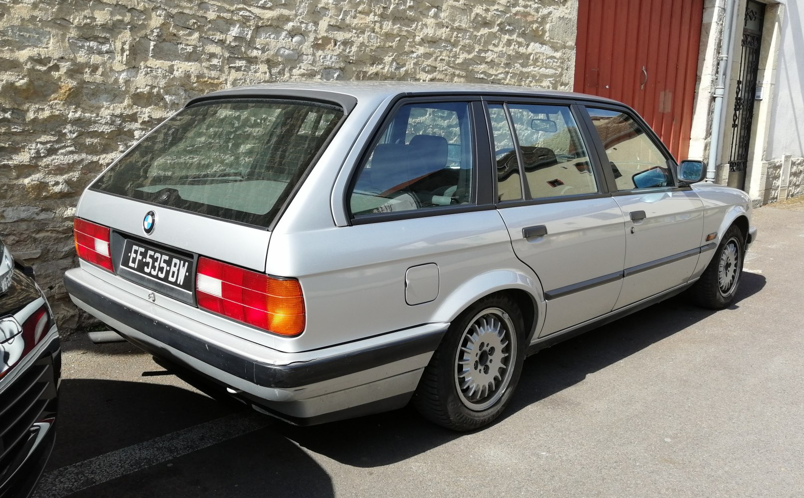 Silver classic station wagon rear side with vintage tail lights and alloy wheels