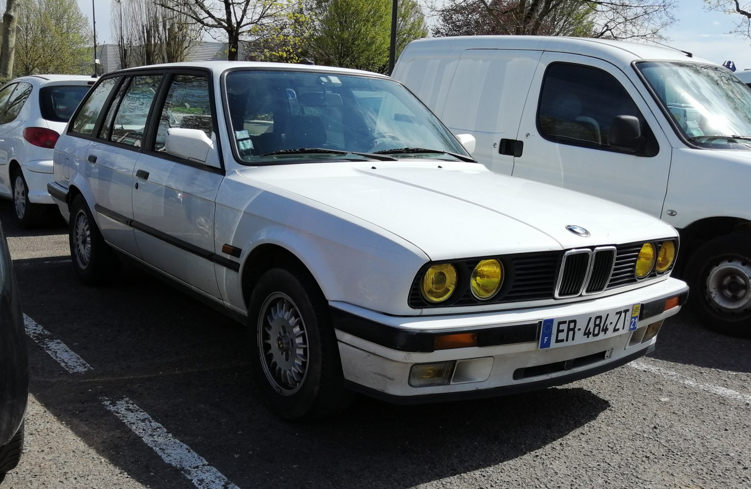 White station wagon with yellow headlights and classic 80s design