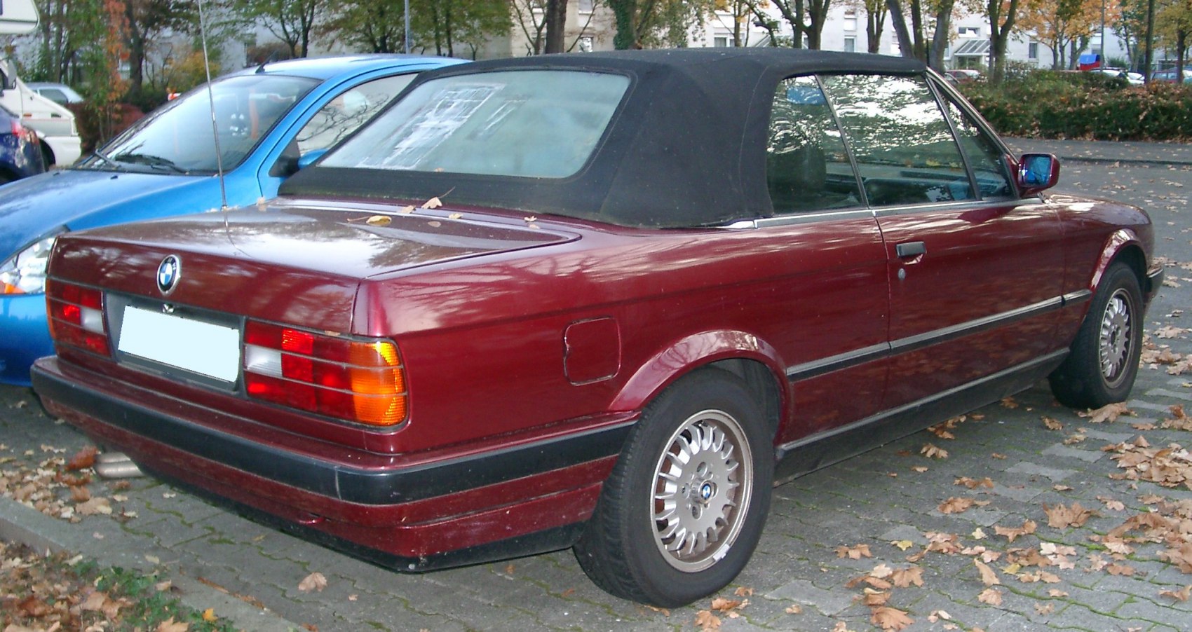 Rear side view of convertible with soft top and multi-spoke alloy wheels