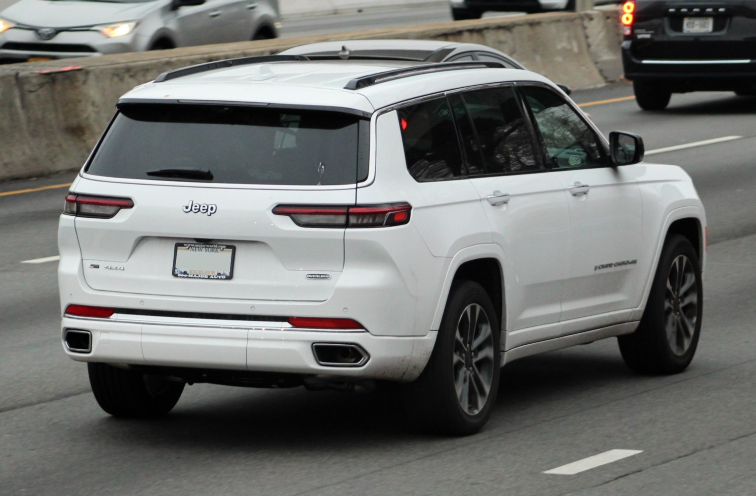 Rear view of mid-size SUV featuring tail lights and dual exhaust tips