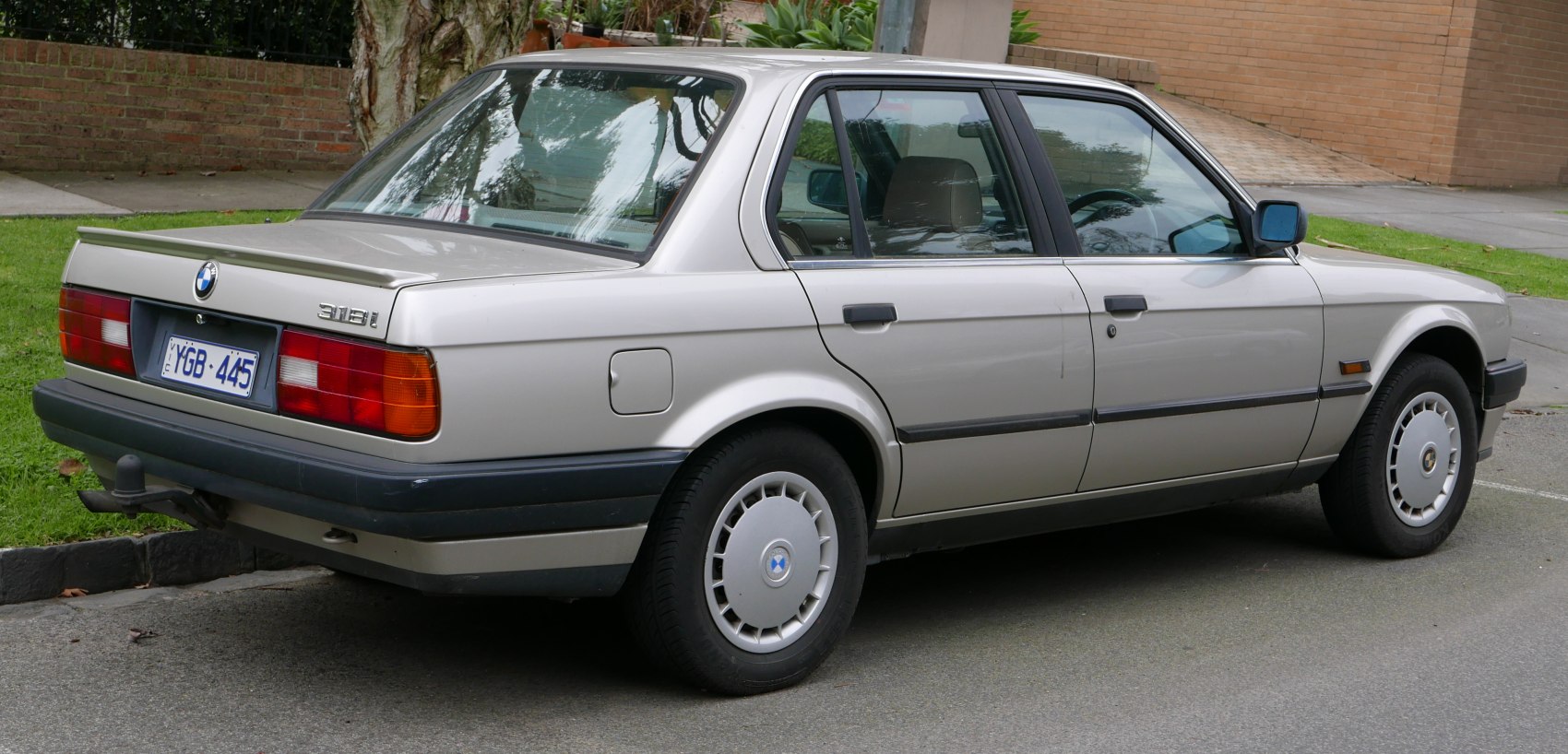 Silver sedan rear side view with alloy wheels and taillights