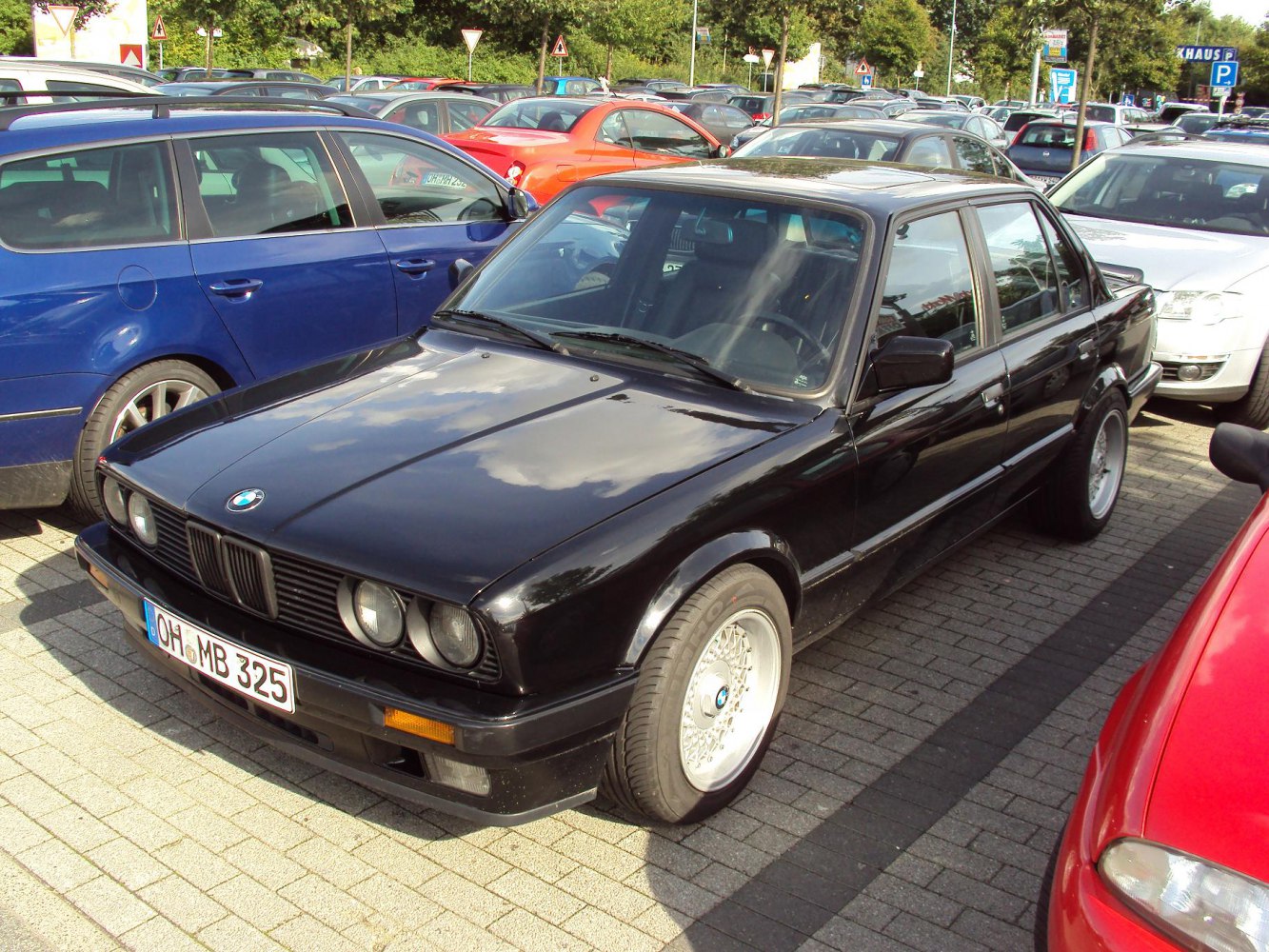Black classic sedan with quad round headlights and mesh alloy wheels.