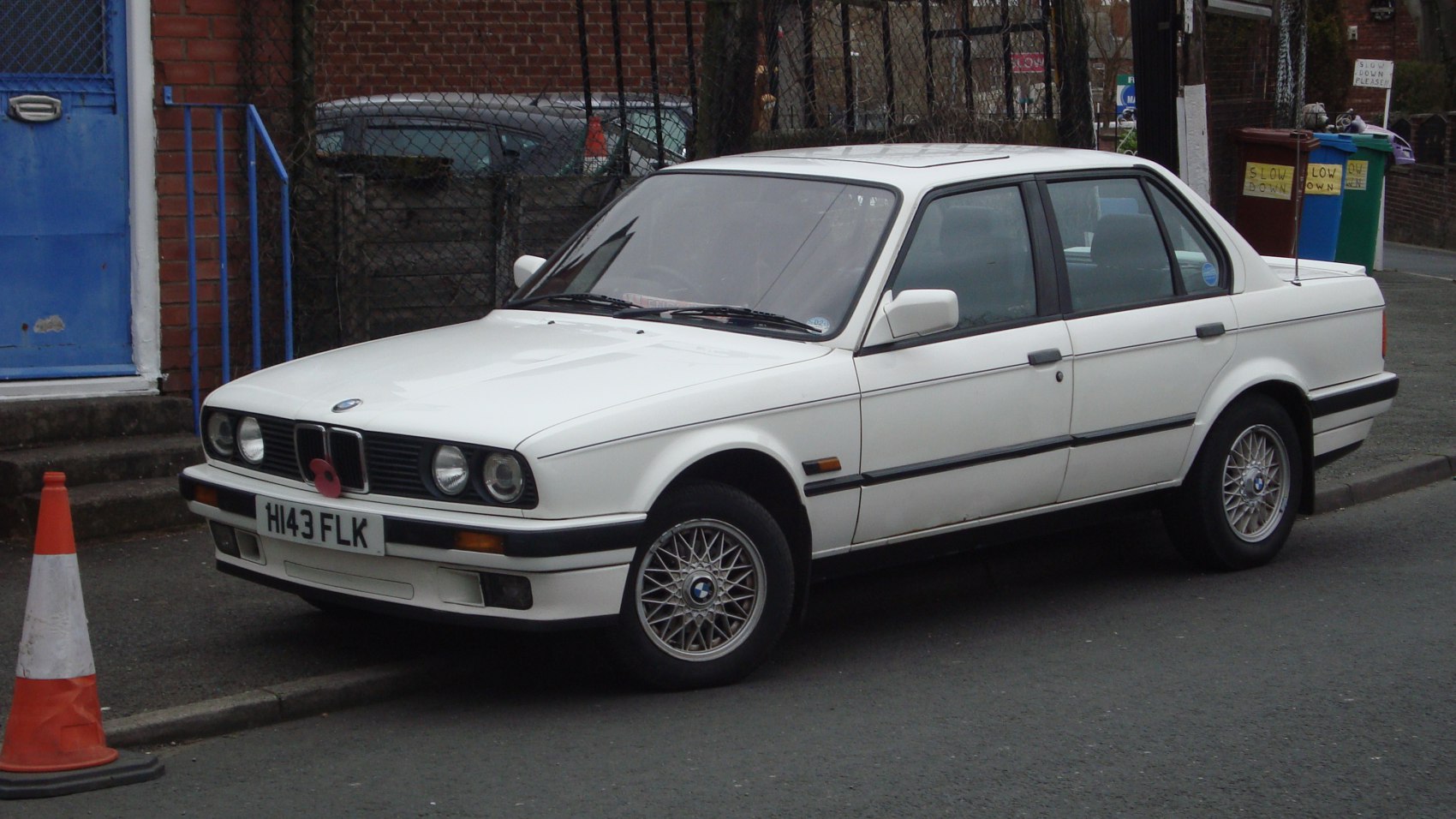 Classic white sedan with twin round headlights and multi-spoke alloy wheels
