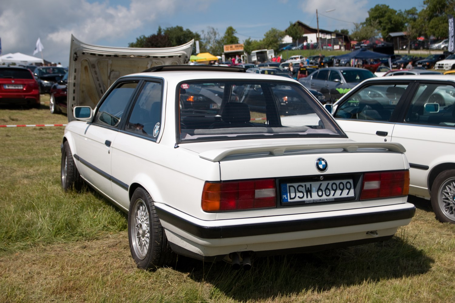 Rear view of white coupe with spoiler and alloy wheels
