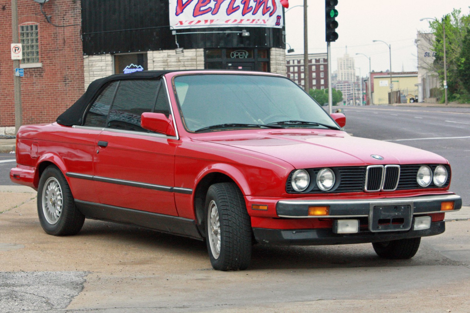 Red convertible with black soft top and quad headlights