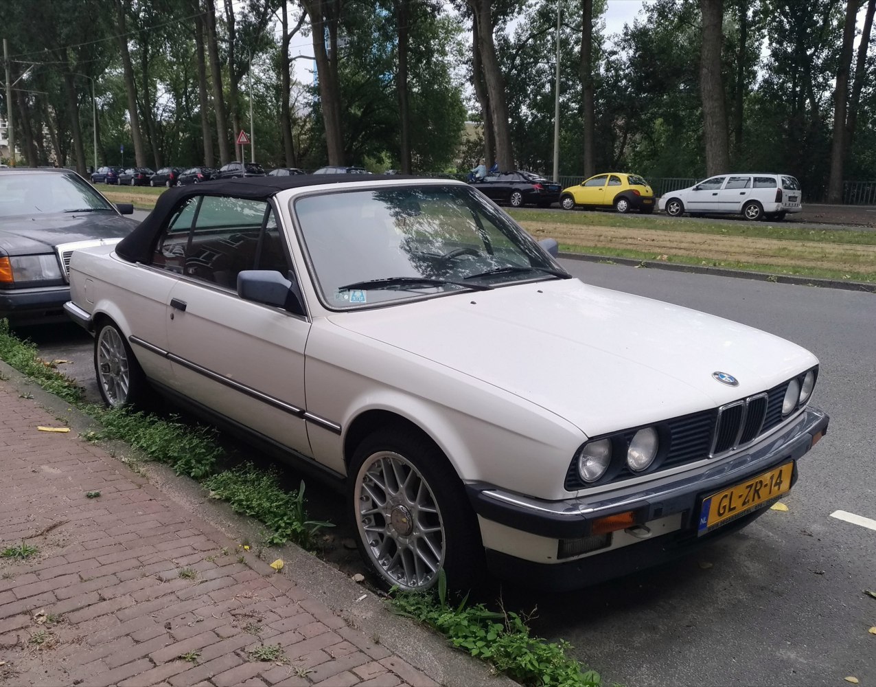 White convertible with black soft top and alloy wheels