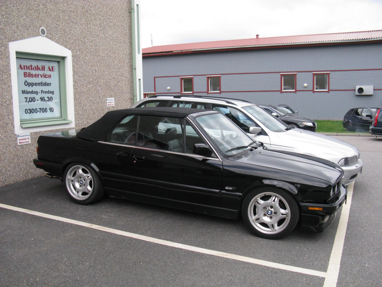 Black convertible with soft top and classic alloy wheels