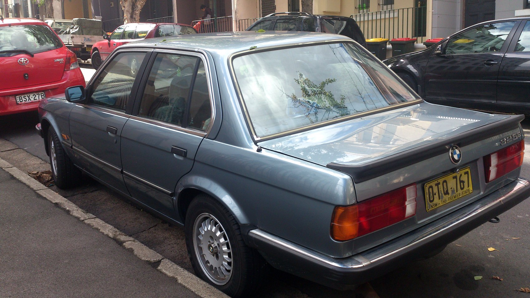 Rear and side view of a vintage sedan with alloy wheels and classic tail lights