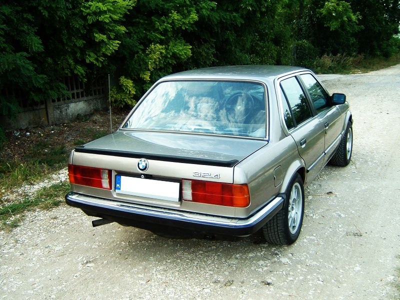 Rear view of a 1980s four-door sedan with rectangular tail lights and compact trunk.